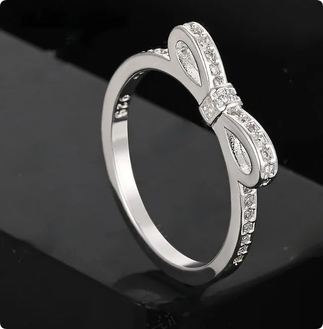 Silver bow-shaped ring with rhinestone and zircon crystal decoration on model hand