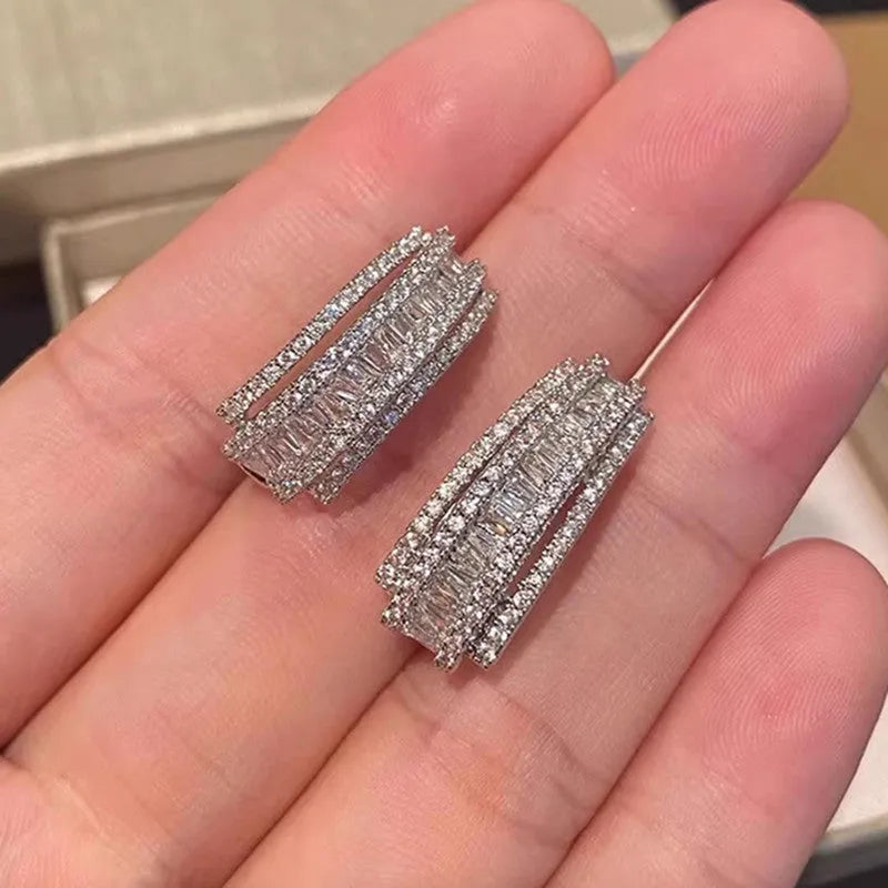 A pair of women's geometric stud earrings with inlaid zircon stones in a white gold colour finish.