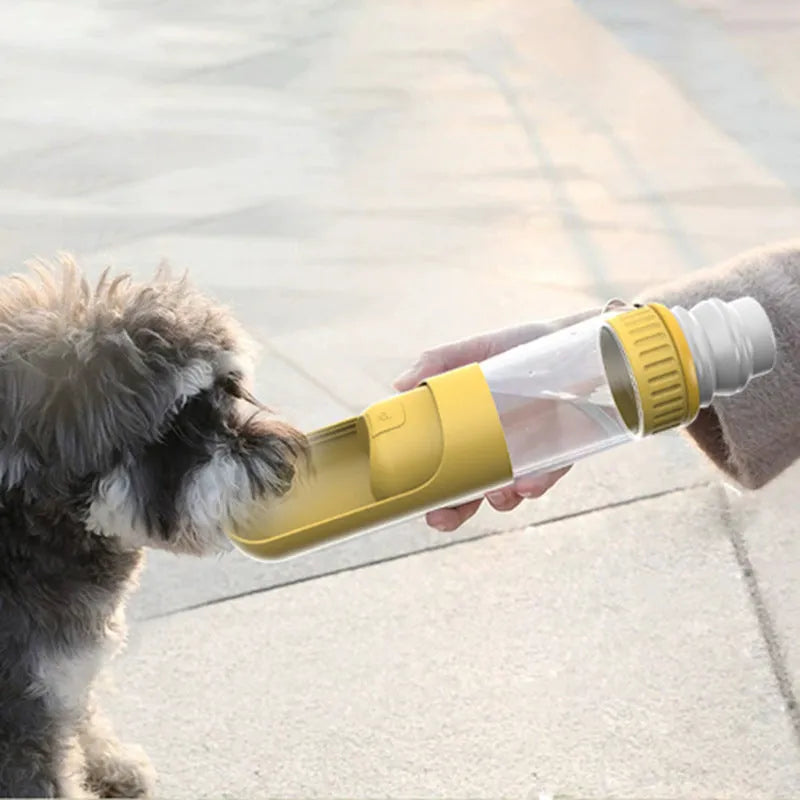 Portable dark blue dog water bottle with integrated drinking bowl, shown alongside a dog.
