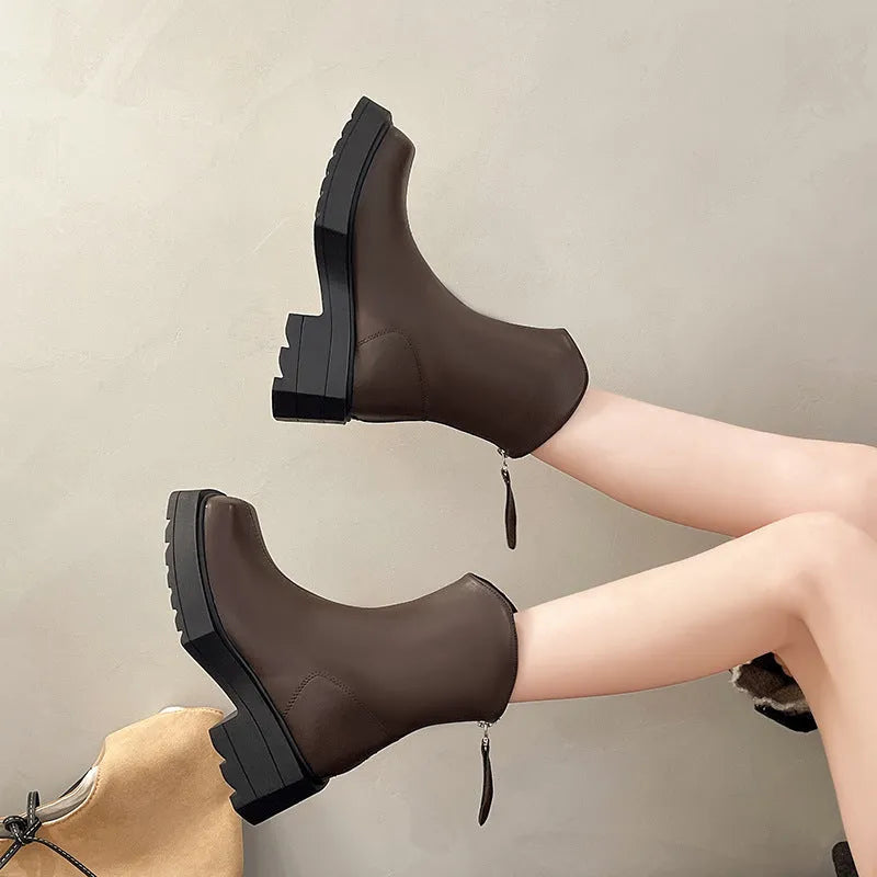 Women's black platform Martin ankle boots with square toe, chunky heel, and back zipper on a plain background.