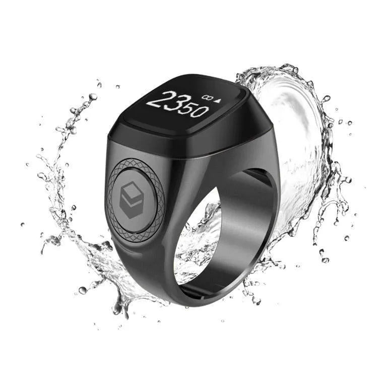 Zikr1 metal smart ring in black with OLED display and single button, shown with charging case.