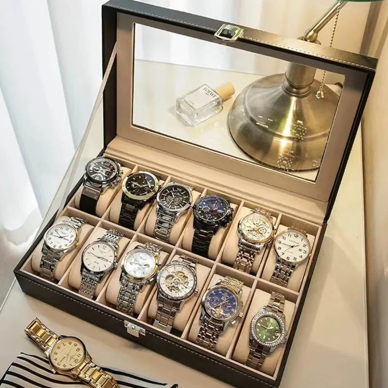 Grey leather watch storage box with transparent lid showing watch cushions inside.