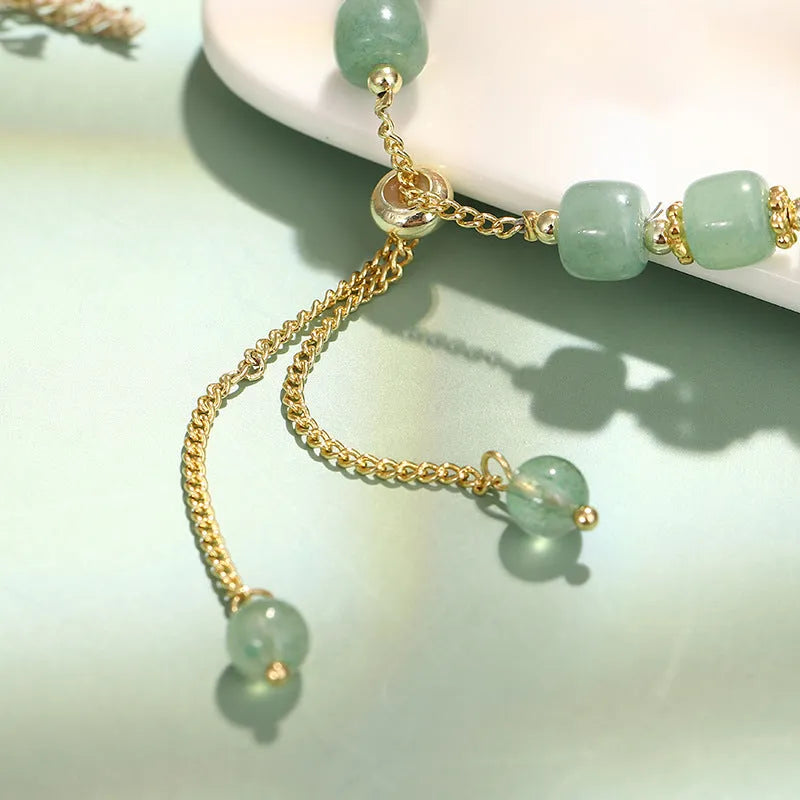 Women's rabbit charm bracelet with green aventurine or strawberry quartz beads, copper and gold accents.