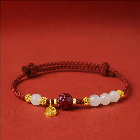 Close-up of a women's bracelet with Hetian jade and red cinnabar beads on an adjustable 925 silver chain.