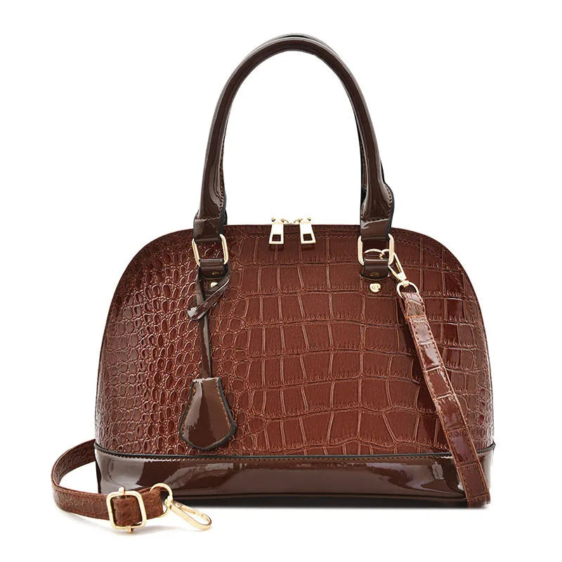 Shell-shaped shiny PU leather crossbody shoulder bag showing black, brown, and red colour options