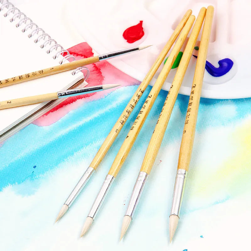 Six wooden brush pens with pointed wool felt tips arranged together as an artist set