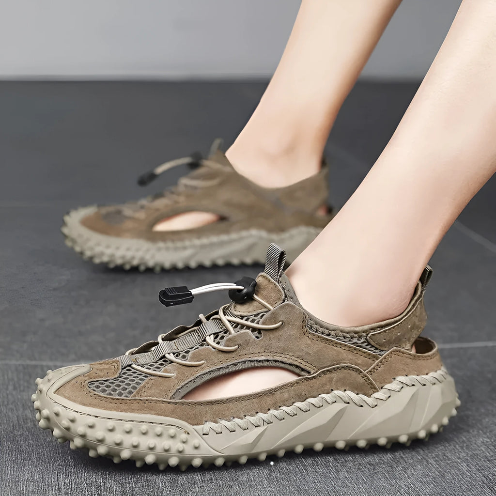 Men's black sports sandals with leather mesh upper and rubber sole showing elastic band fastening