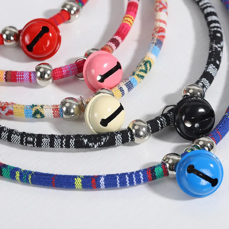 Coloured adjustable nylon pet collar with ethnic pattern, plastic quick-release buckle, and small bell.