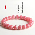 Women's red rhodochrosite crystal bracelet with geometric beads and a Longevity Lock charm.