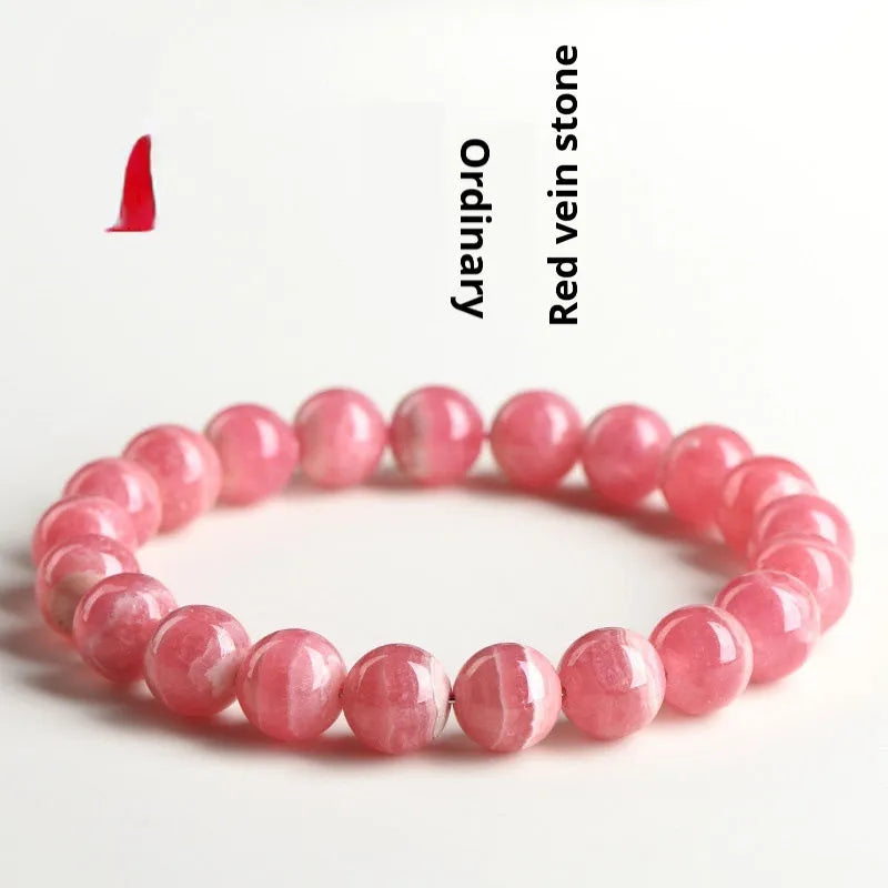 Women's red rhodochrosite crystal bracelet with geometric beads and a Longevity Lock charm.