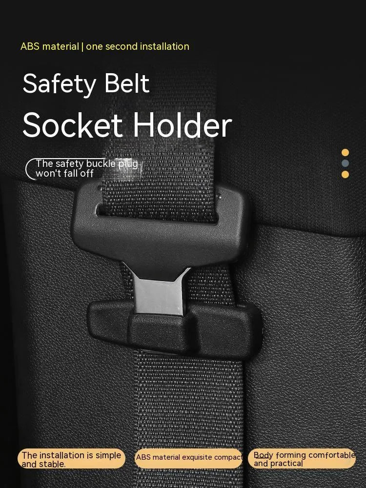 Two black ABS plastic universal car seat belt stopper clips on a grey background.