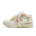 Creamy white low-top retro skate shoes with candy-colour sewing thread details on microfiber upper.