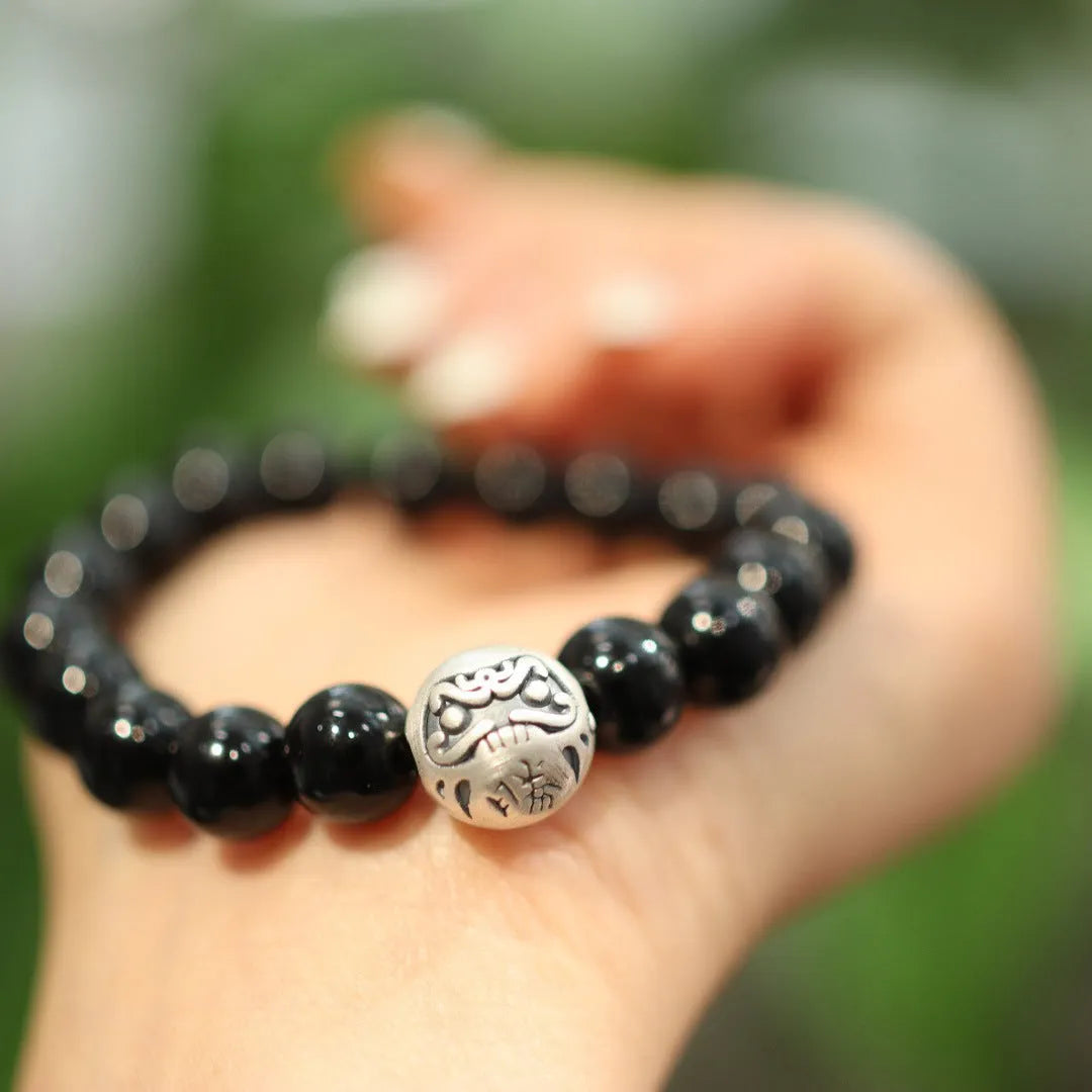 Handmade women's black agate bracelet with 10mm beads and a sterling silver clasp on a wrist.