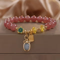 Red strawberry quartz beaded bracelet with alloy charms and rhinestone details for women.