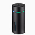 Compact black aluminium car humidifier and essential oil diffuser with USB cable on a desk.