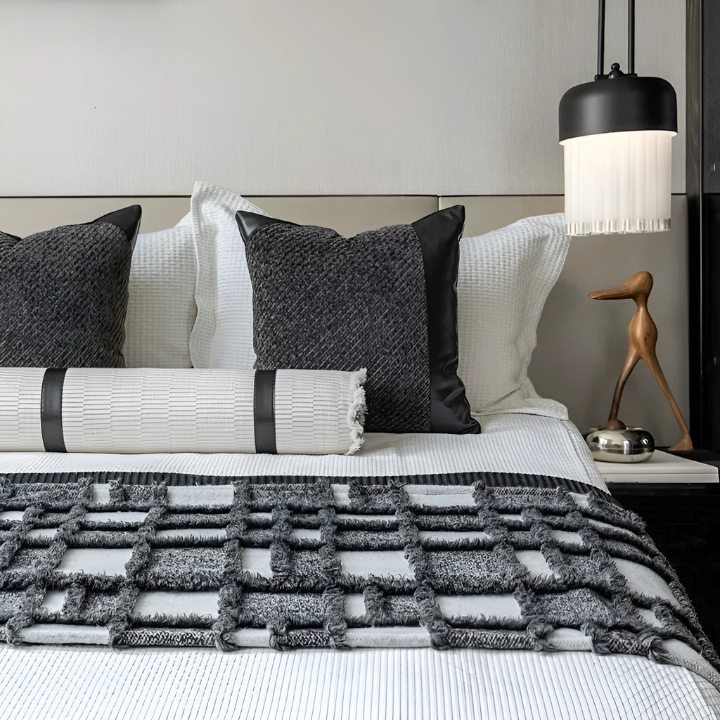 Modern grey and white plaid bed runner blanket set with leather round pillow on a bed