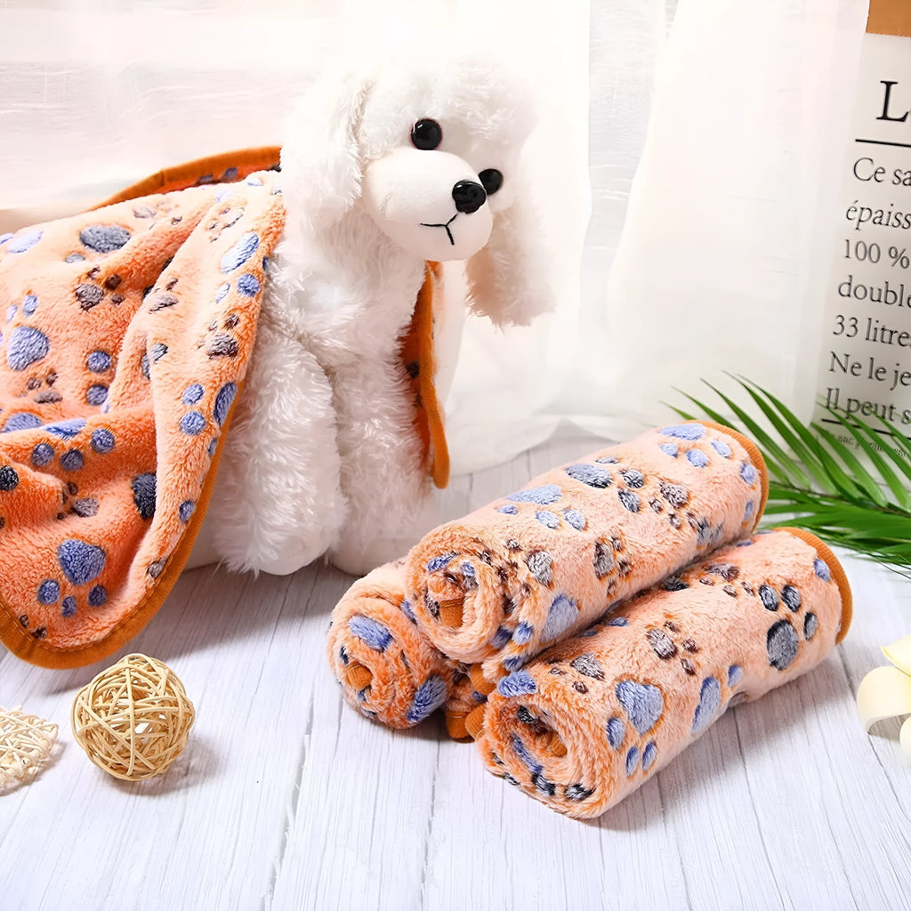 Soft coral fleece dog blanket with paw print design shown in beige colour on a dog bed.