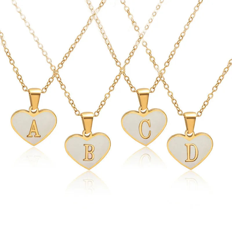 Heart-shaped letter necklace with white shell detail on gold-plated stainless steel chain