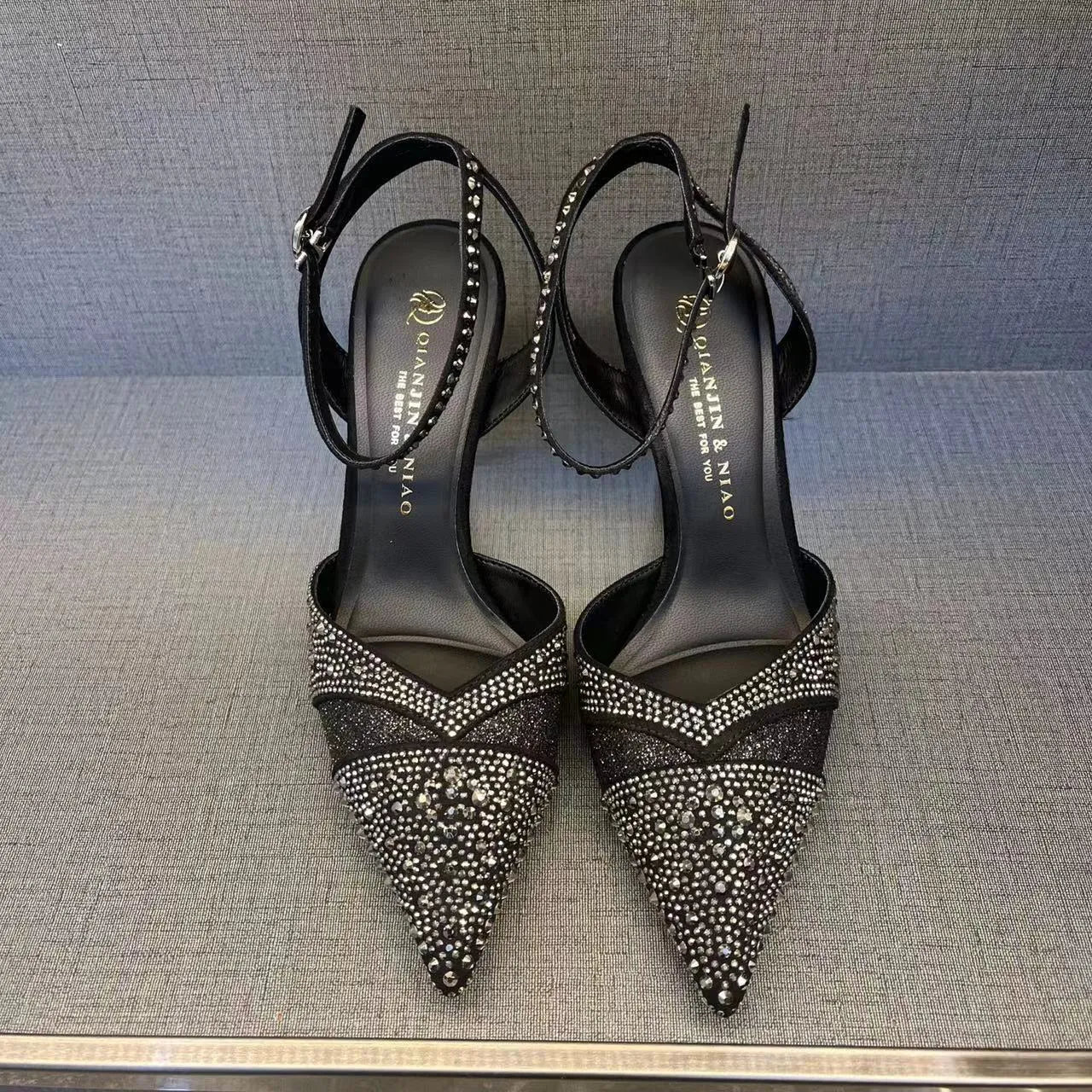Women's black hollow high heels with stiletto heel, pointed toe, and red sole