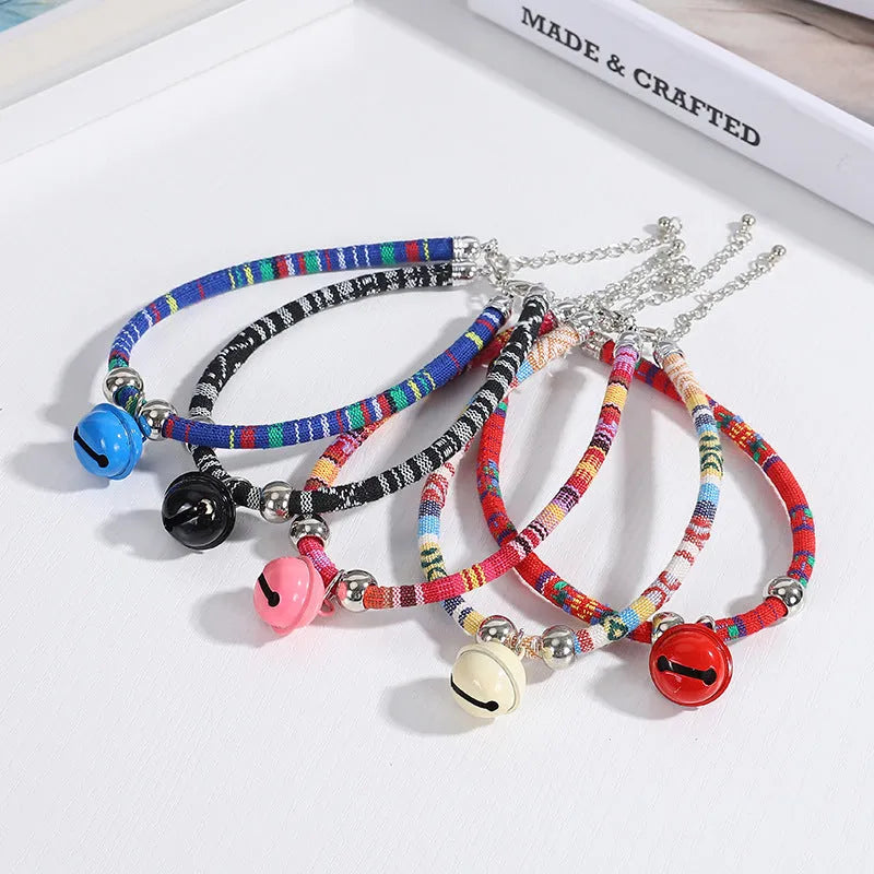 Coloured adjustable nylon pet collar with ethnic pattern, plastic quick-release buckle, and small bell.
