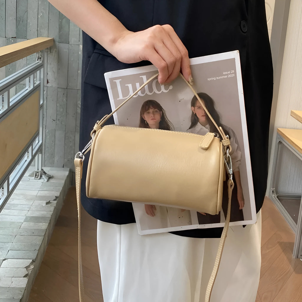 Genuine vegetable tanned leather crossbody phone bag with cylindrical shape and single shoulder strap