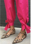 Leopard print women's pumps with pointed toe, cross strap, and a chunky low heel.