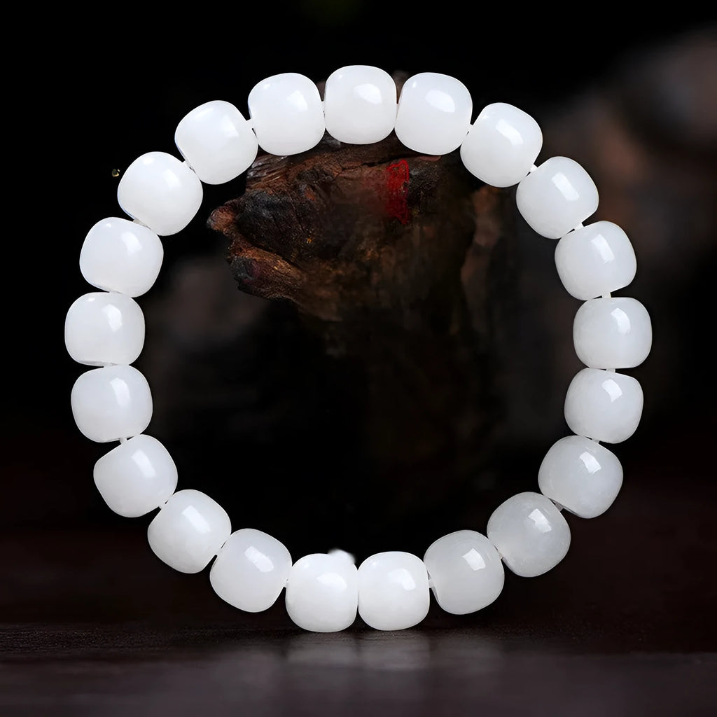 White Hetian jade barrel bead bracelet on a wrist, showing unisex casual style.
