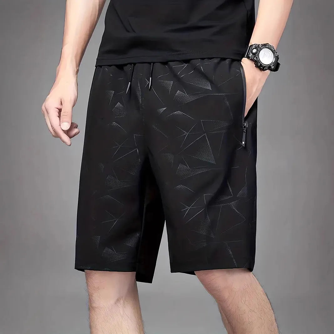 Man wearing loose black sports shorts made of polyester fabric, showing relaxed fit and elasticated waistband.