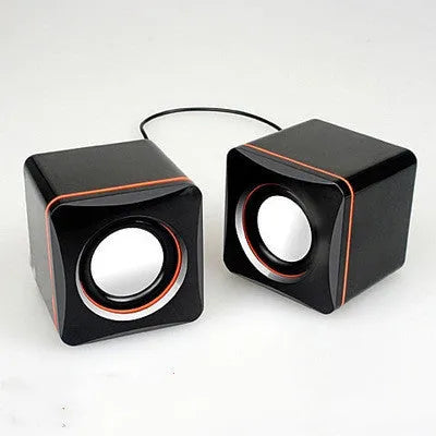 Small square black USB-powered 2.0 computer speaker on a desktop.