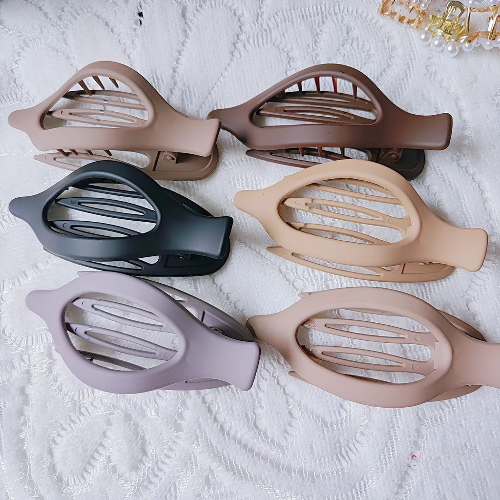 Six plastic hair clips with quadrilateral shape and frosted grip surface in nude and rose red colours