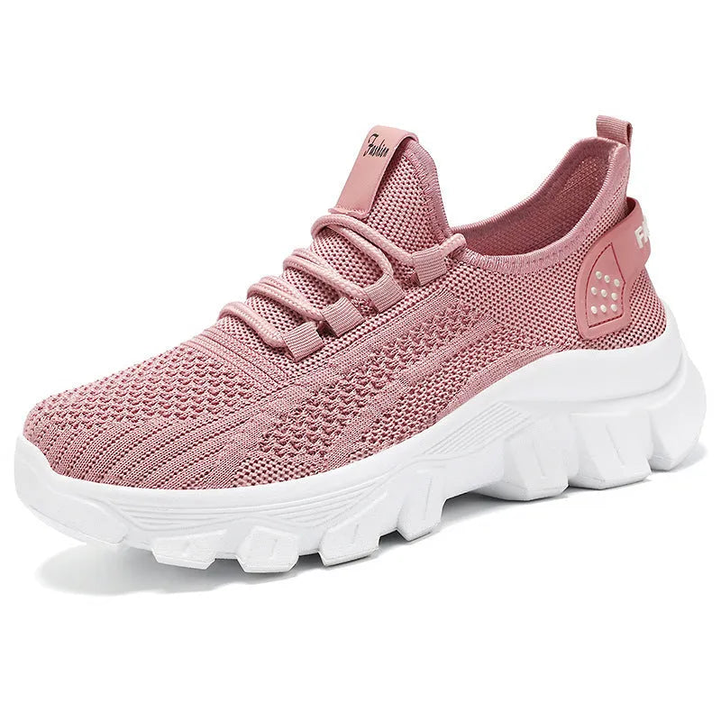 Women's white Flyknit running sneakers with lace-up front and thick PVC sole on a neutral background.