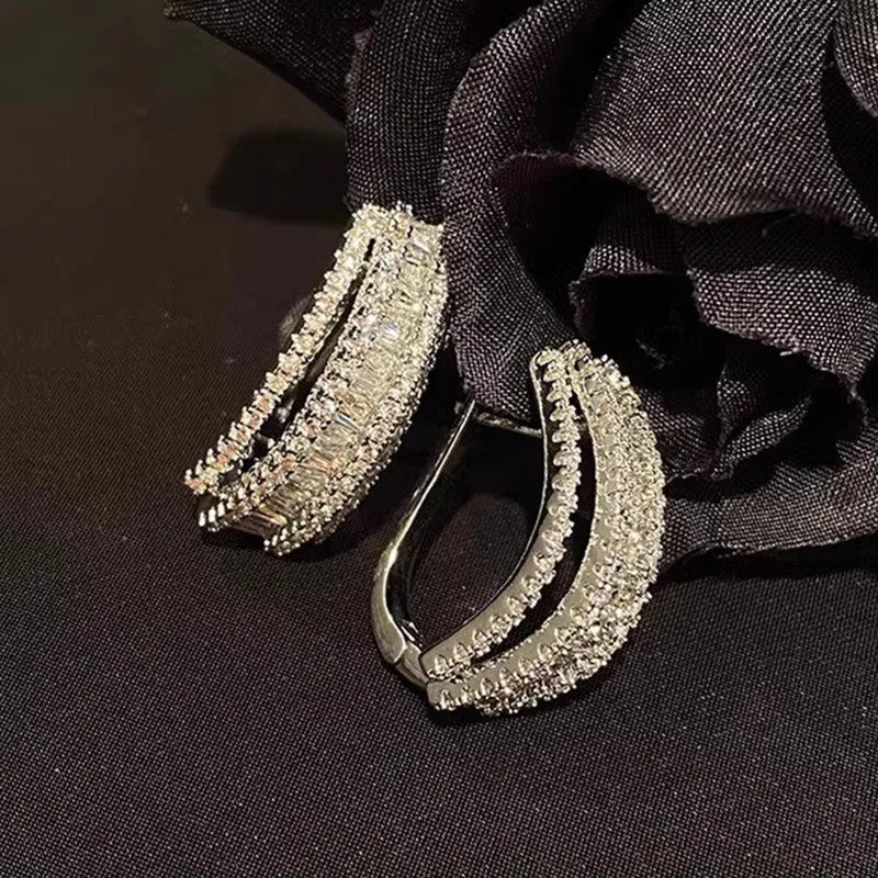 A pair of women's geometric stud earrings with inlaid zircon stones in a white gold colour finish.