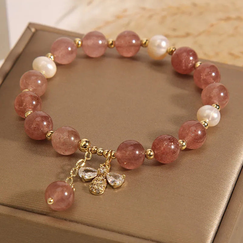 Women's pink strawberry quartz and white freshwater pearl bracelet with zircon accents on wrist