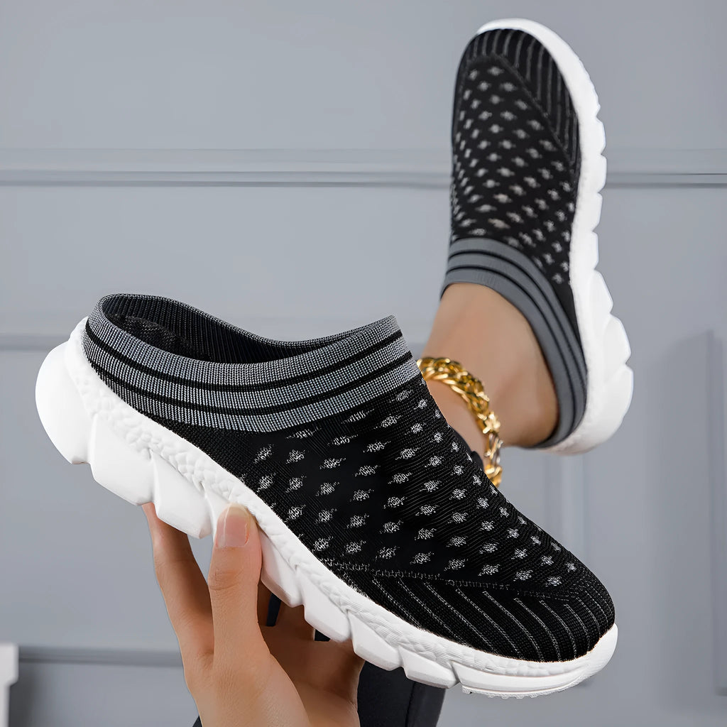 Women's black Flyknit slipper sock with striped pattern and hollowed-out design on a solid background.