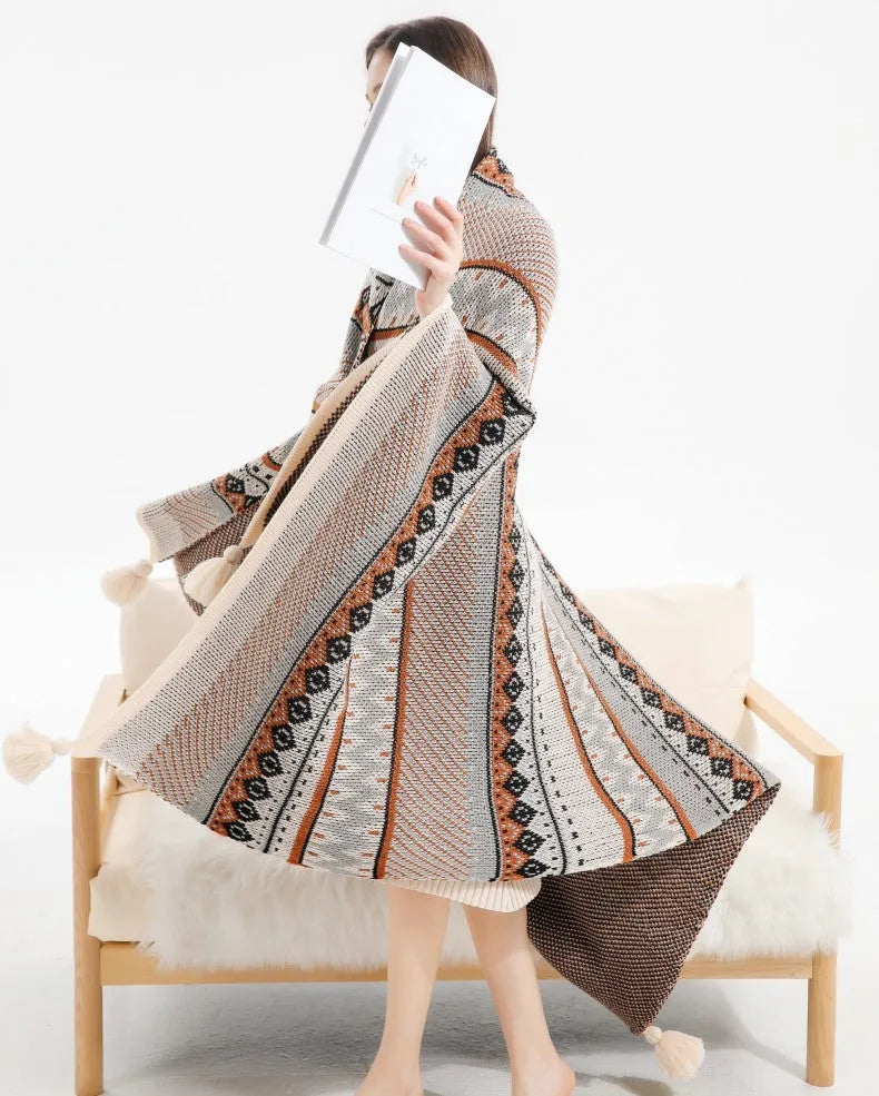 Bohemian style acrylic sofa blanket with tassel fringe in a geometric blue and pink pattern.