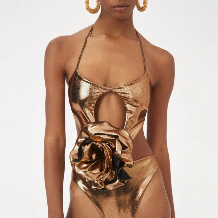 Gold coloured one-piece halterneck swimsuit with hollow-out details on a mannequin.