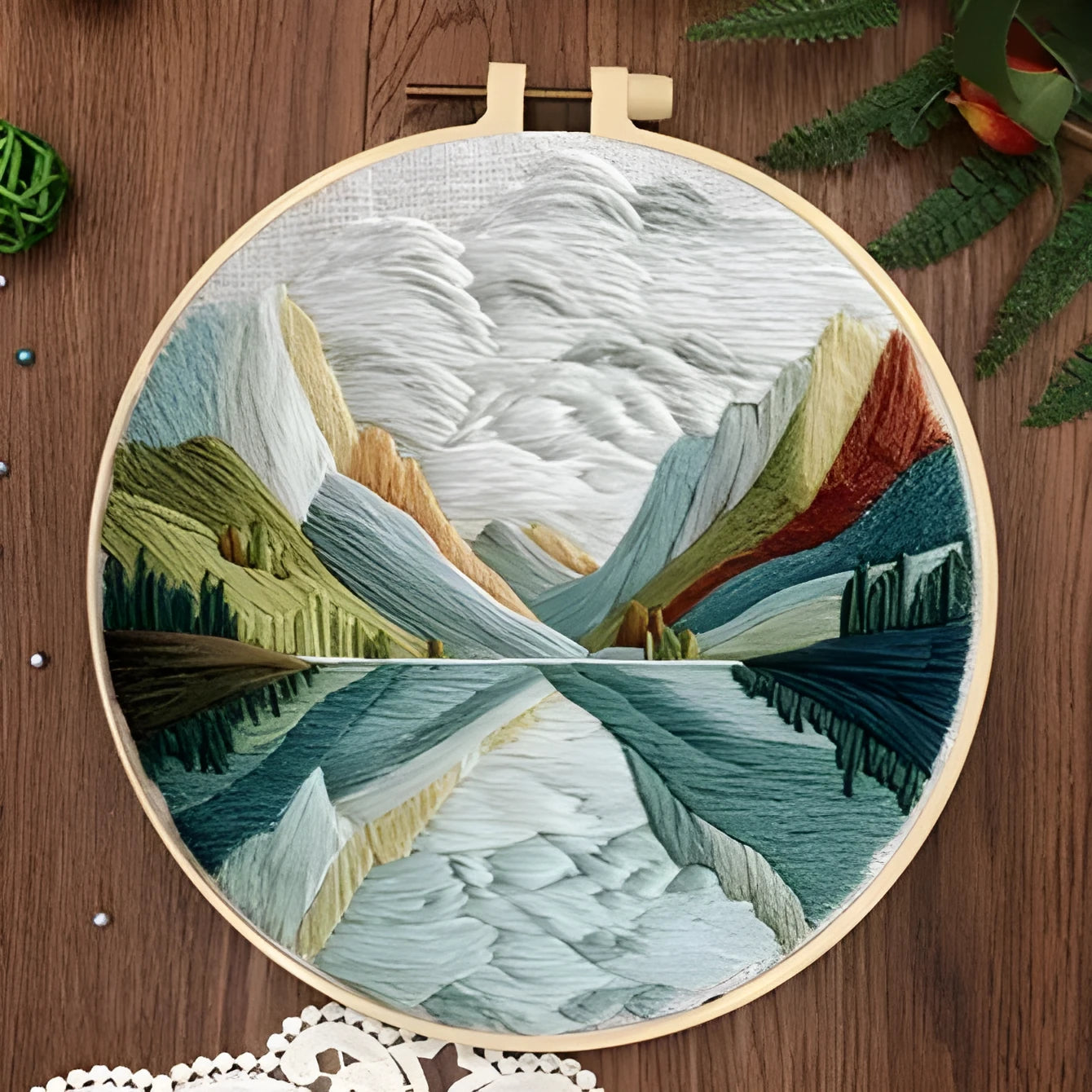 DIY landscape embroidery kit with bamboo frame, printed fabric, and thread on a table