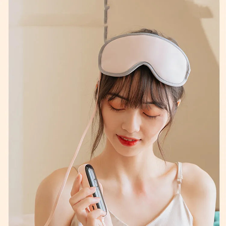Portable green eye steam massage mask with USB cable on a grey background