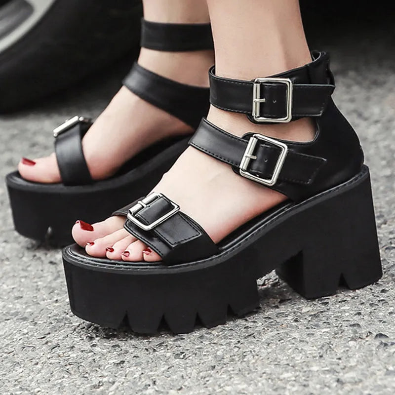 Black women's sandals with chunky heel, thick sole, round toe, buckle detail, and back zipper.