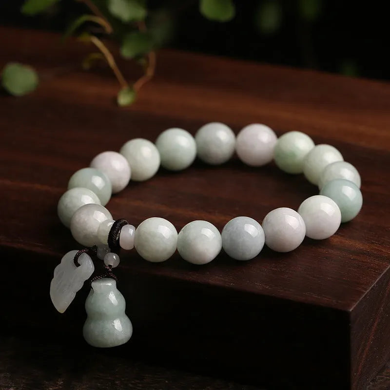 Natural emerald jade bracelet with hanging geometric beads and Buddhist elements