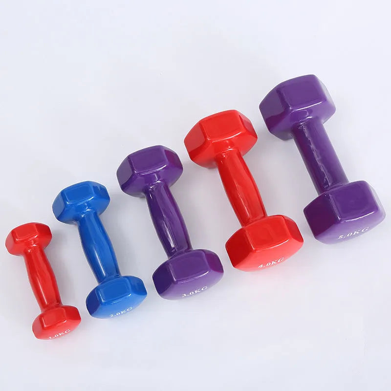 A set of bright colourful plastic dumbbells in different sizes on a light floor.