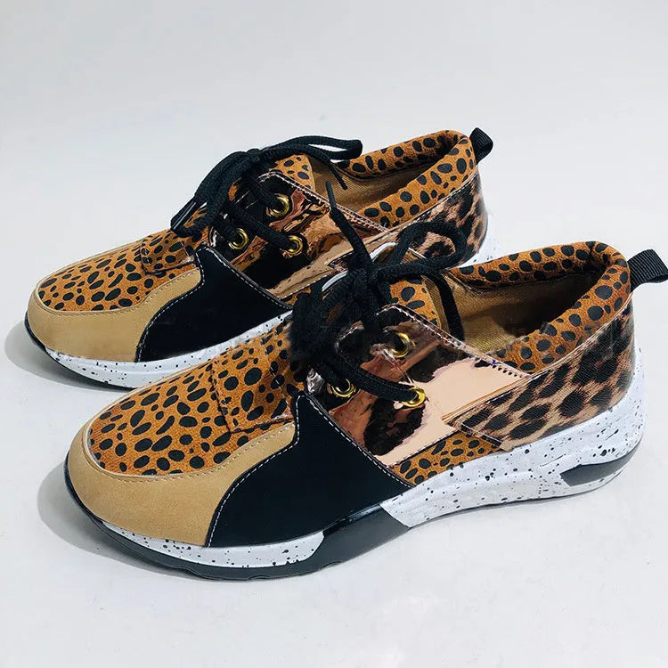 Women's black casual sneakers with a suede upper and a low wedge heel on a plastic sole.