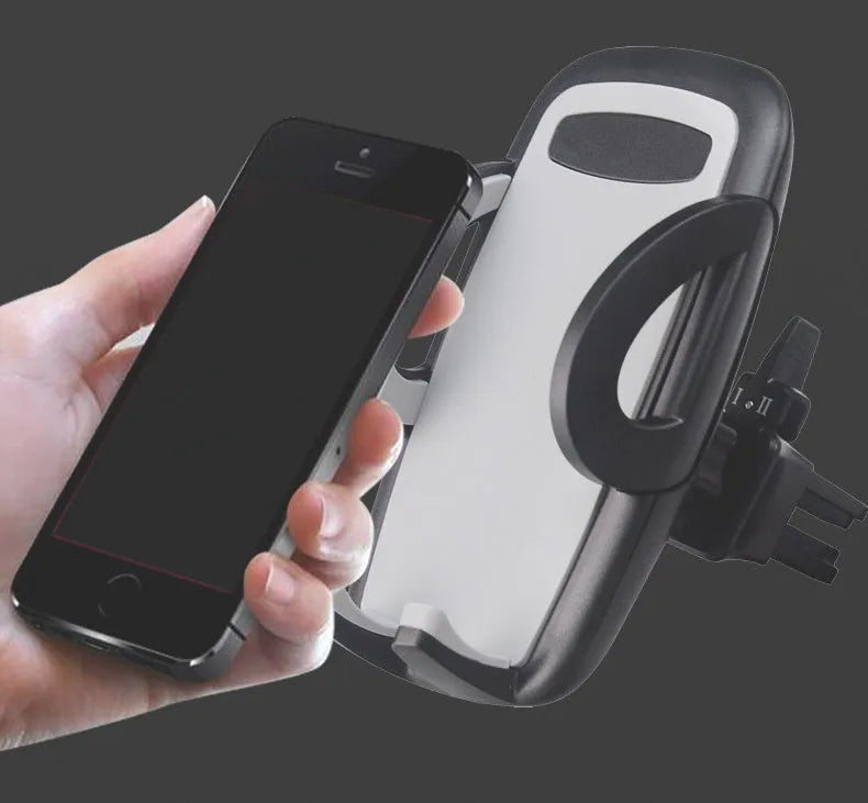 Black plastic mobile phone holder attached to car air conditioning outlet for hands-free navigation