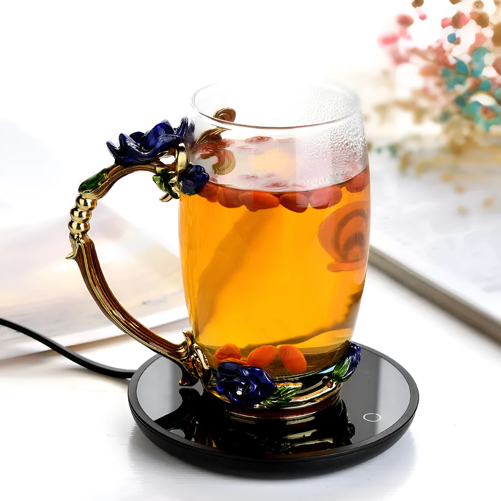 Black electric coffee mug warmer with tempered glass surface and temperature switch on a desk