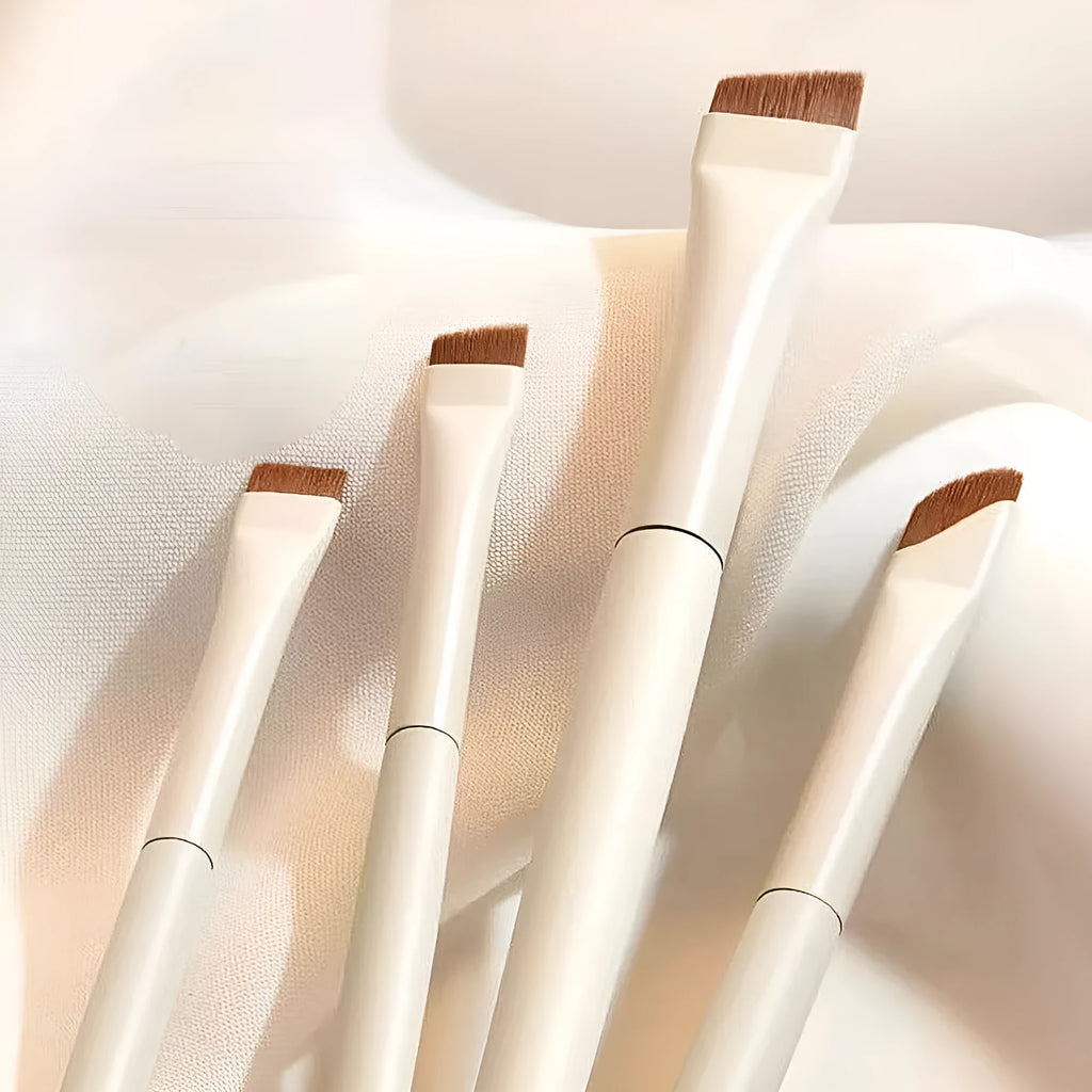 Four angled eyeliner and eyebrow brushes with fine tips in leather case for precise makeup application