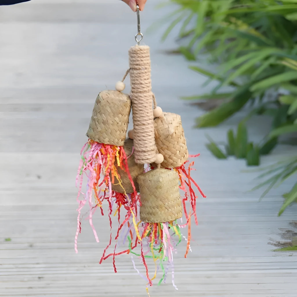 Parrot toy with wood pieces, sisal rope and colourful shredded paper strips hanging for bird enrichment