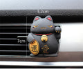 Black and white resin fortune cat decorative clip for car air conditioning vent with aromatherapy function.