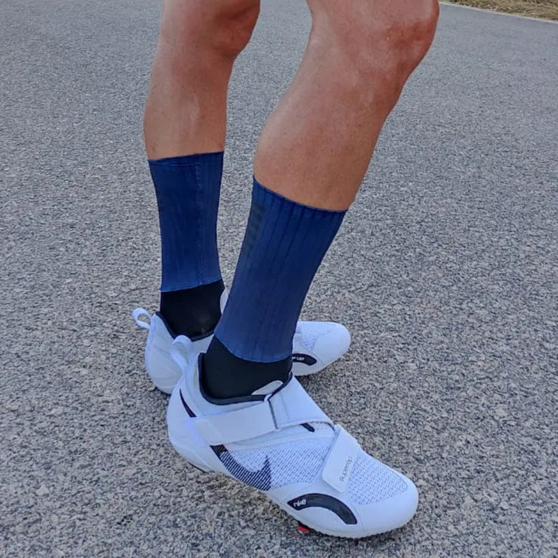 Athletic cycling and running socks in chemical fibre blend fabric, shown in orange, black, purple, white, grey or dark blue.