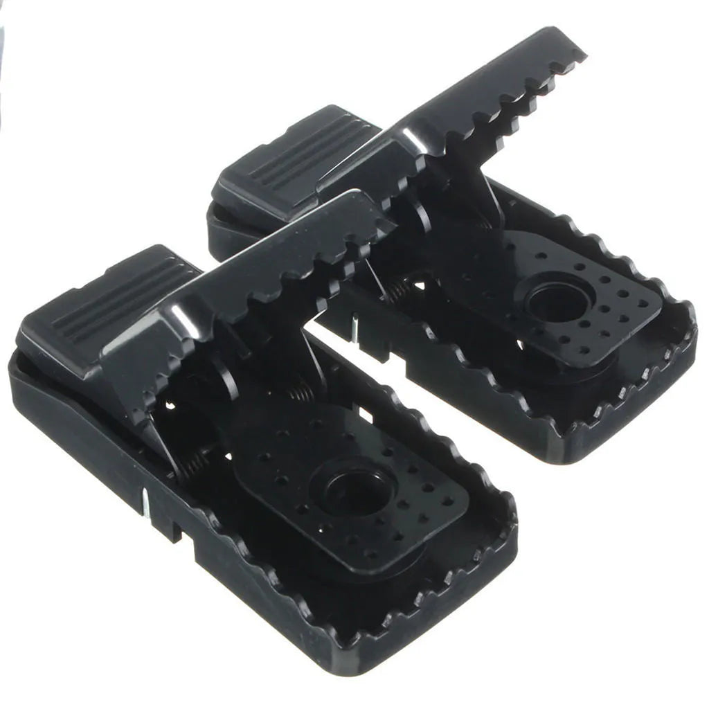 Six black plastic snapping mousetraps showing bite-trap mechanism with ruler showing 11cm length