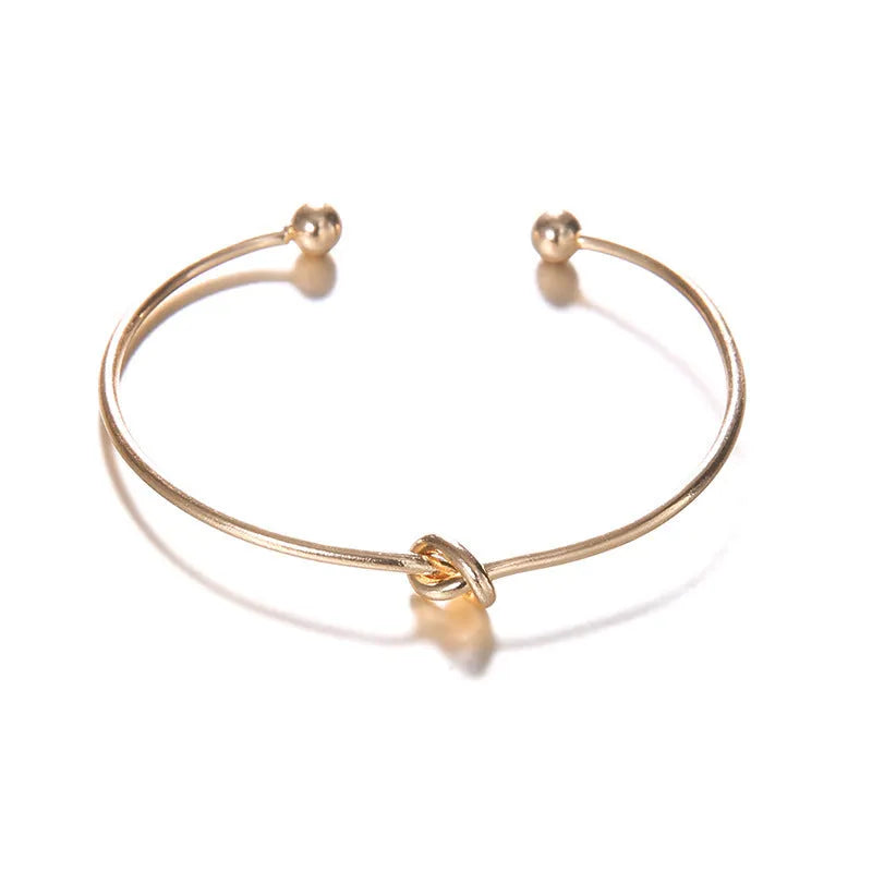 Gold electroplated women's vintage cuff bracelet with arrow knot detail